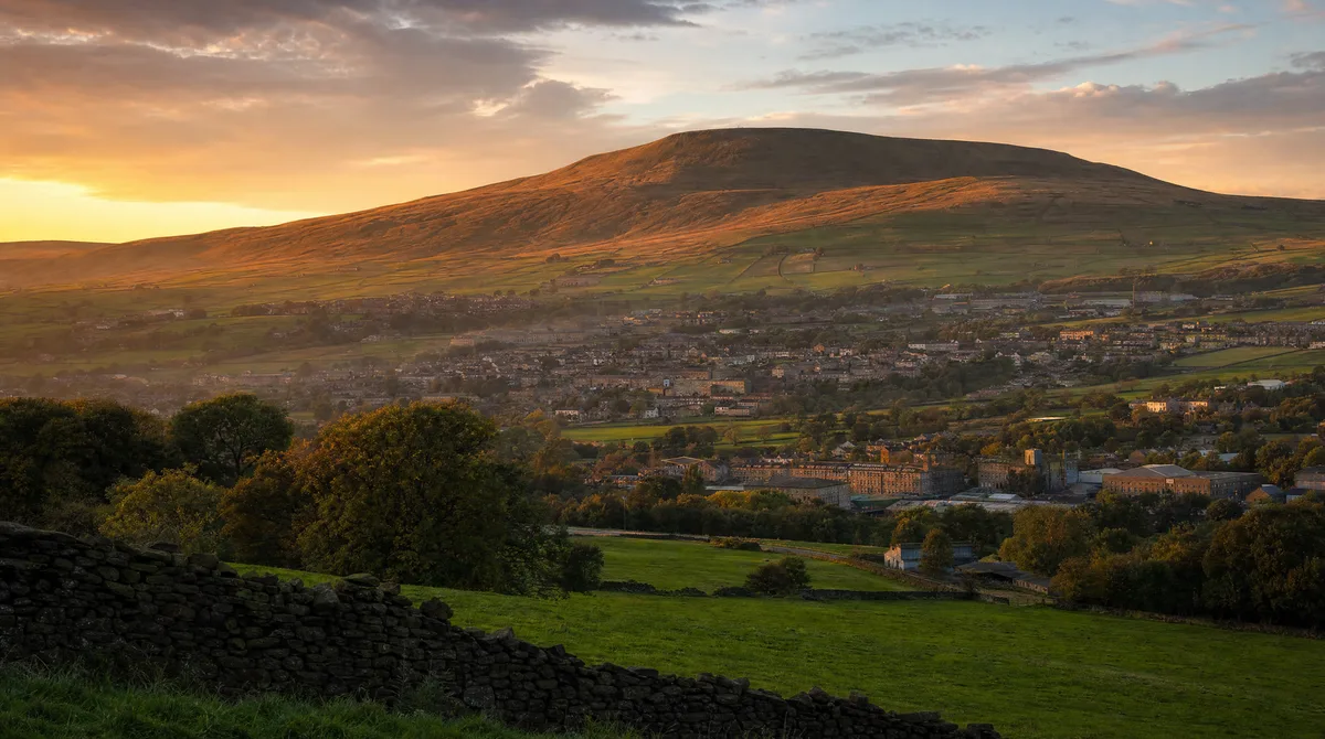 Pendle Hill rising above Barrowford and the valley at golden hour